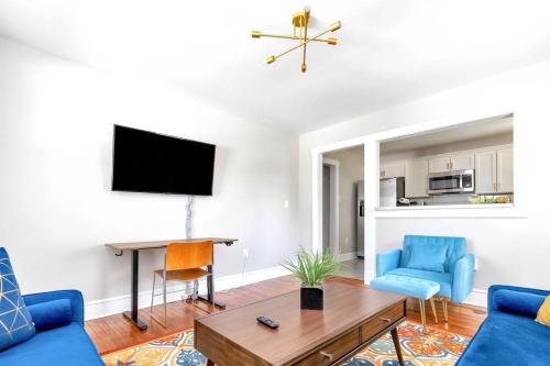 a living room with a blue couch and a table at Stay, Play and Pass Go at the Monopoly Penthouse! in Richmond