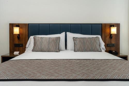 a bedroom with a large bed with two pillows at Riu Palace Kukulkan - Adults Only - All Inclusive in Cancún