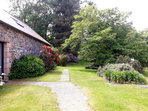un giardino fiorito e una casa in pietra di La petite maison dans la prairie a Lamballe Armor