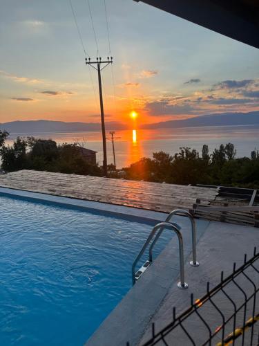 a swimming pool with a sunset in the background at CHRIS sopo in Elshani