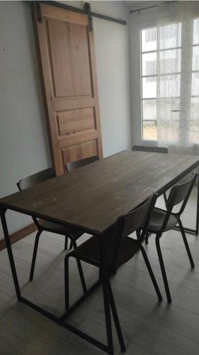 - une grande table en bois avec des chaises dans l'établissement Appartement très proche mer Rez de jardin 5 pers, à Notre-Dame-de-Monts