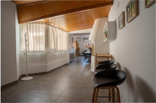 a hallway with a row of black stools at Ático céntrico con vistas a Los Molinos in Campo de Criptana