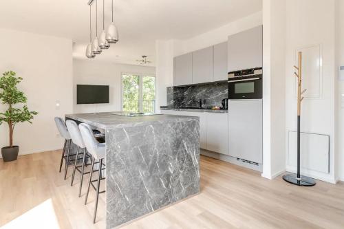 a kitchen with a marble counter top and white cabinets at THE WOS Apartments in Mönchengladbach