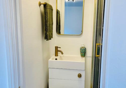 a bathroom with a sink and a mirror at Zen Garden Hideaway. Close to Harry Potter&trains. in Watford