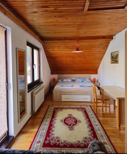 a bedroom with a bed and a table and a rug at Peaceful Vacation Villa & Garden in Sarajevo
