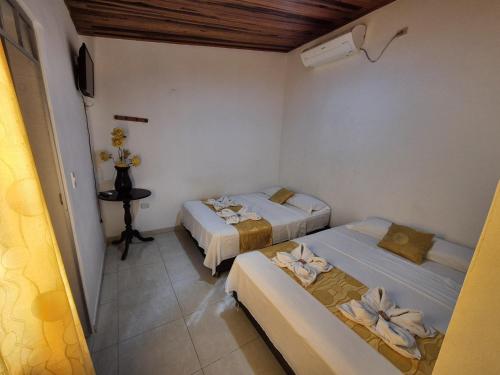 a room with two beds and a table in it at Casa Hotel Diana Luz in Villavieja