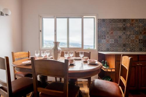 a dining room table with wine glasses and a window at Casa da Silva home in Funchal in Funchal