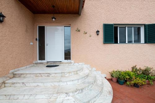 a front door of a house with stairs and a window at Casa da Silva home in Funchal in Funchal