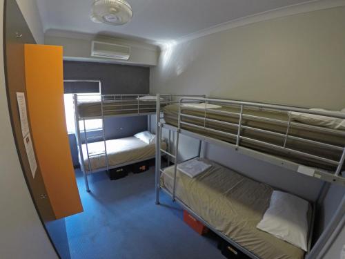 a small room with two bunk beds in it at Global Backpackers Port Douglas in Port Douglas
