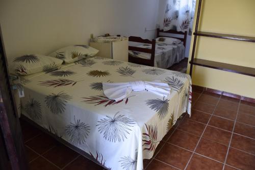 a bedroom with a bed with a white comforter at Pousada Panorama do Mar in Fortaleza