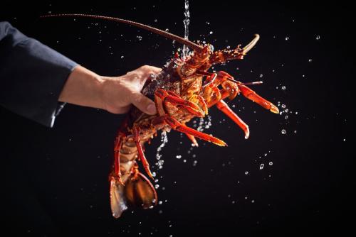 a person holding a large lobster in their hand at Regent Chongqing - Complimentary 1st round mini bar daily in Chongqing