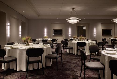 a banquet room with tables and chairs with white tablecloths at Kimpton Claret Hotel by IHG in Denver