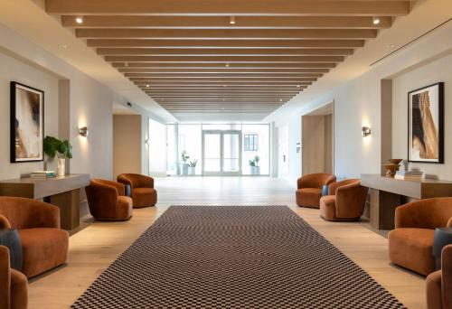 a waiting room with chairs and a rug on the floor at Kimpton Claret Hotel by IHG in Denver