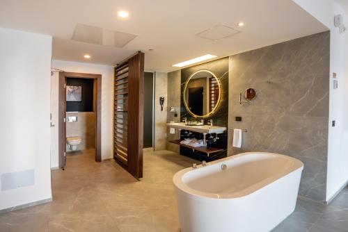 a bathroom with a tub and a sink at Riu Palace Kukulkan - Adults Only - All Inclusive in Cancún