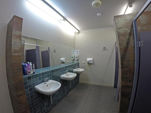 a bathroom with two sinks and a mirror at Global Backpackers Port Douglas in Port Douglas