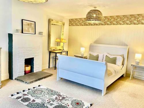 a bedroom with a white bed and a fireplace at Hob Lane Farm Cottage - Peak Park in Oughtibridge