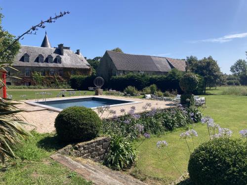 une maison avec une piscine dans la cour dans l'établissement Magnifique Château d'Hémevez au coeur de la presqu'île du Cotentin, à Hémevez
