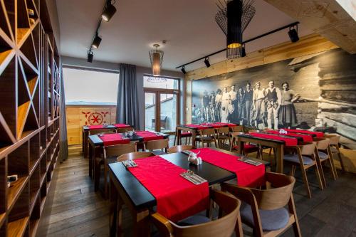 a dining room with tables and red napkins at Hotel Kopieniec Fizjo- Med & SPA in Murzasichle