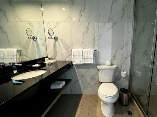 a bathroom with a toilet and a sink and a shower at Best Western Plus Urban Larco Hotel in Lima