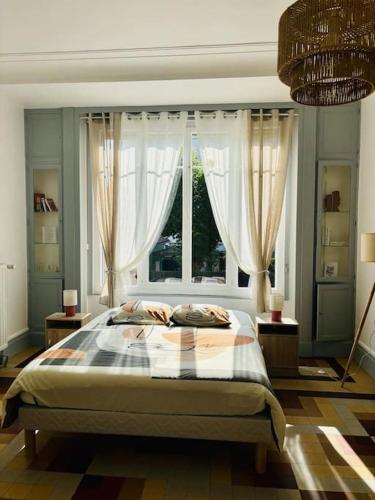 a bedroom with a large bed in front of a window at Le Magaline in Sainte-Savine