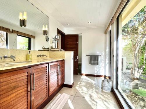 a bathroom with two sinks and a large window at Searenity Villa in Grand Baie