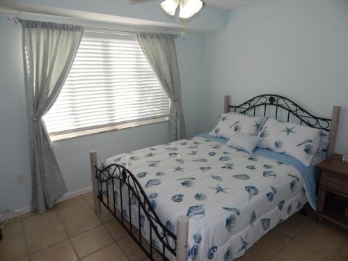 a bedroom with a bed with a blue and white comforter at Cayman Cottage in Summerland Key