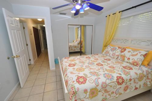 a bedroom with a bed and a ceiling fan at Cayman Cottage in Summerland Key
