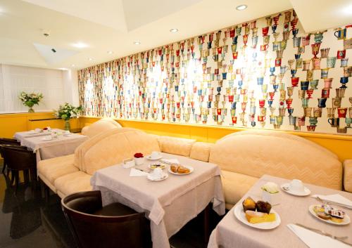 a restaurant with couches and tables with food on them at Hotel D'Este in Milan