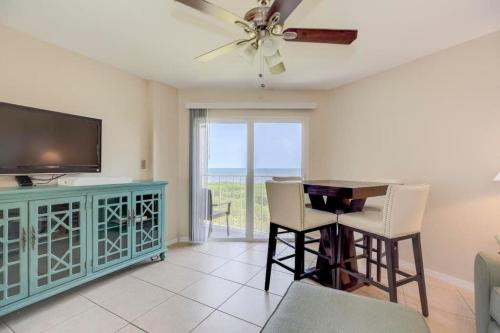 a living room with a television and a table and chairs at Key Largo 2BR 2BA Oceanfront with Pool in Tavernier