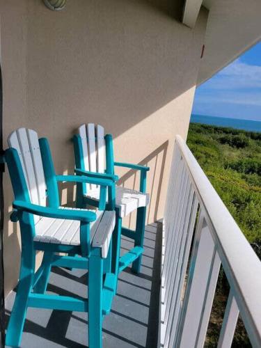 two chairs sitting on a balcony looking out at the ocean at Key Largo 2BR 2BA Oceanfront with Pool in Tavernier
