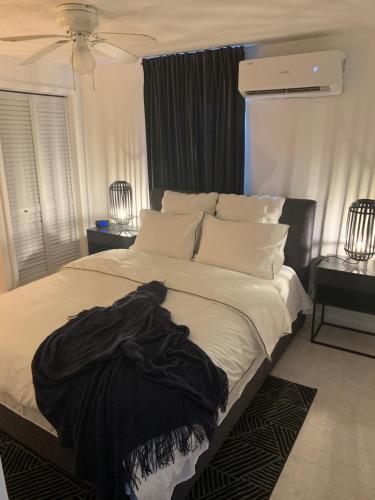 a bedroom with a bed with a black blanket on it at La Casita in Miami