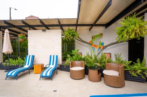 a patio with chairs and plants and a lizard on the wall at KC Hotel San Jose in San José