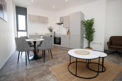 a kitchen and a living room with a table and chairs at High Point 2 bed Apartment in Bradford
