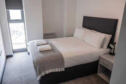 a bedroom with a bed with two towels on it at High Point 2 bed Apartment in Bradford