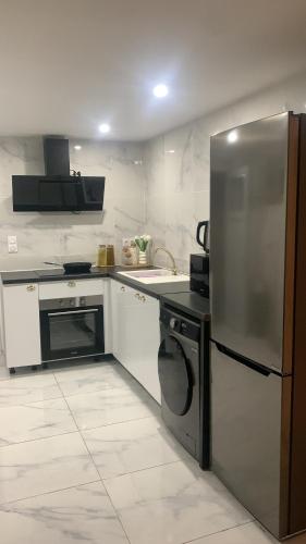 La cuisine est équipée d'un réfrigérateur en acier inoxydable et d'un lave-vaisselle. dans l'établissement Appartement, à Saint-Martin-de-Valgalgues