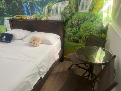 a bedroom with a bed and a table with a painting at Hotel deluxe oasis de la colina boutique in Girardot
