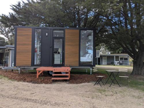 a tiny house with a picnic table next to a tree at Roses Gap View in Dadswells Bridge