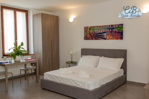 a bedroom with a bed and a table and a desk at Casa Bonita Rho in Rho
