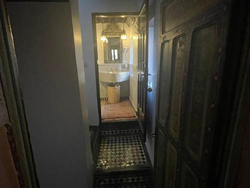a hallway of a bathroom with a sink and a mirror at Riad Fes Baraka & SPA in Fès