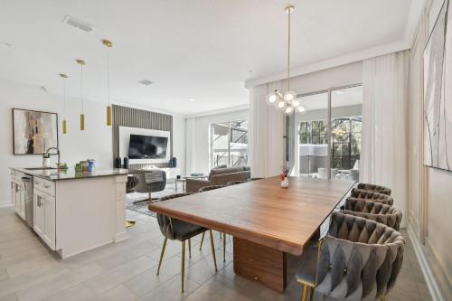 a kitchen and dining room with a wooden table and chairs at Storey Lake - Private Pool King Bed 4BD/3BA in Kissimmee