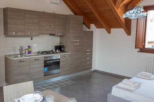 a kitchen with wooden cabinets and a table in a room at Casa Bonita Rho in Rho