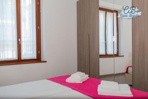 a bedroom with a bed with a pink blanket and a mirror at Casa Bonita Rho in Rho