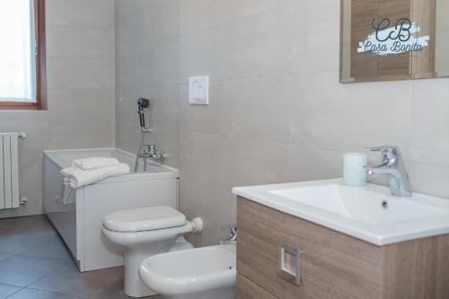 a white bathroom with a toilet and a sink at Casa Bonita Rho in Rho