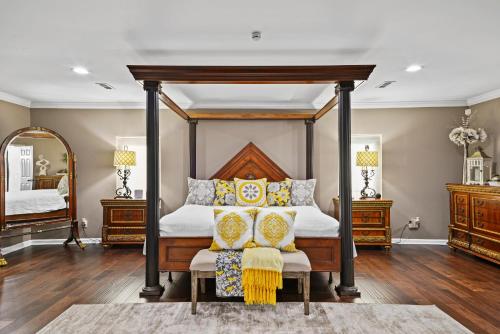 a bedroom with a canopy bed with yellow pillows at Casa de Lorie the ultimate vacation home in Ooltewah