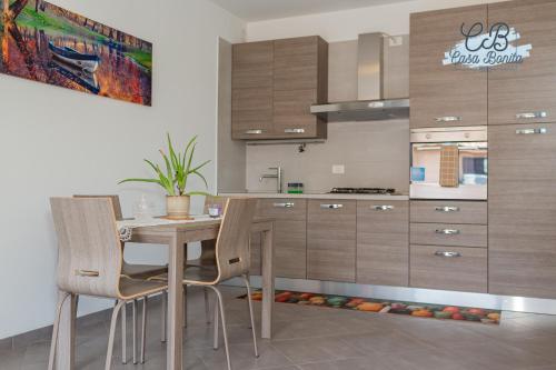a kitchen with a wooden table and chairs at Casa Bonita Rho in Rho