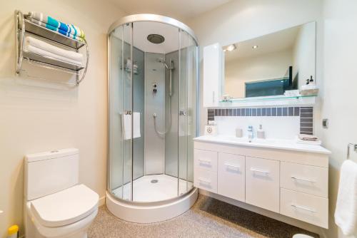 a bathroom with a shower and a toilet and a sink at City Lights Boutique Lodge in Rotorua