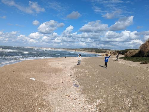 a couple of people walking on the beach at aqueduct villa cesarea jacuzzi in Caesarea