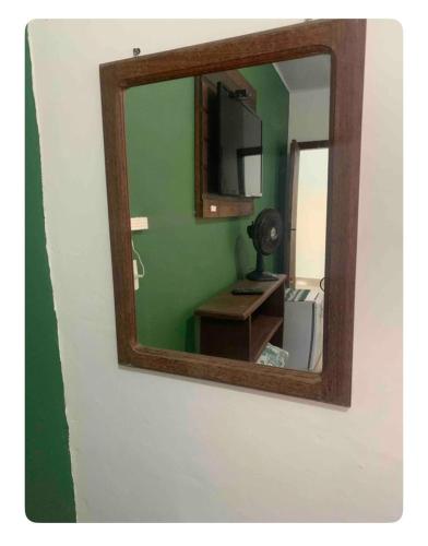 a mirror on a wall with a desk in a room at Vicentina Hospedagem in Tiradentes