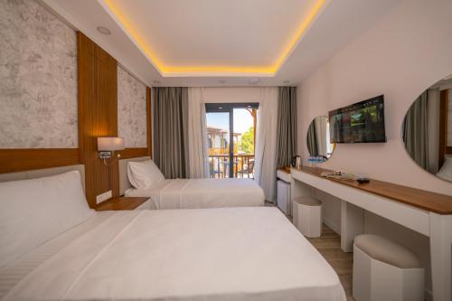 Una habitación de hotel con dos camas y un escritorio. en Marvelous Sarıgerme, en Sarigerme