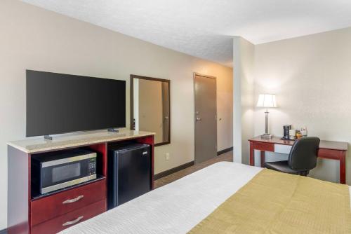 a hotel room with a bed and a flat screen tv at Best Western Auburn/Opelika Inn in Opelika